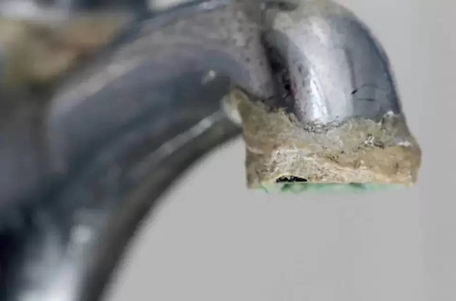 Salida de una llave con una costra gruesa de mineral.